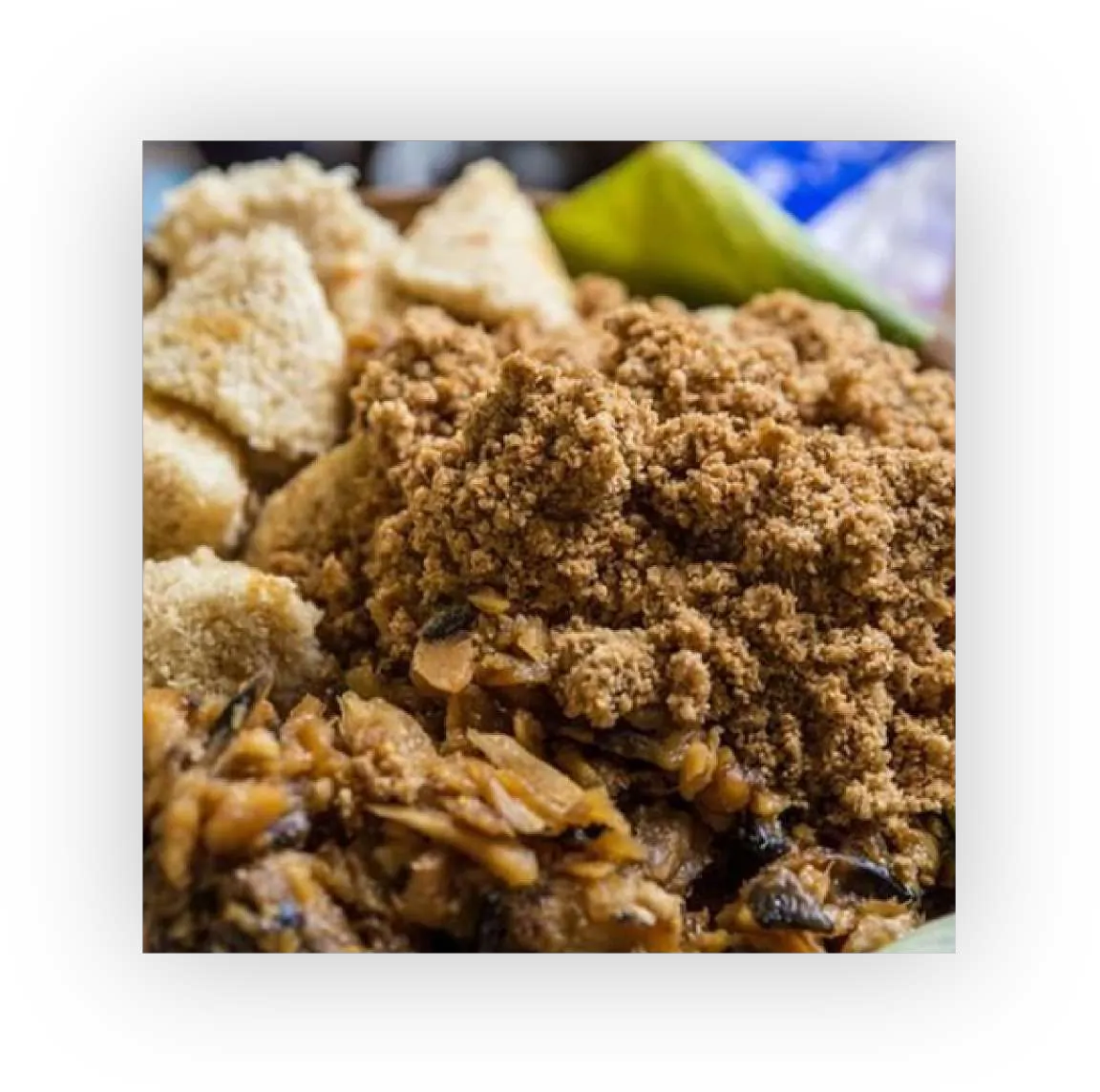 Tiwul tradisional berwarna cokelat, bertekstur butiran kasar, disajikan dengan parutan kelapa.