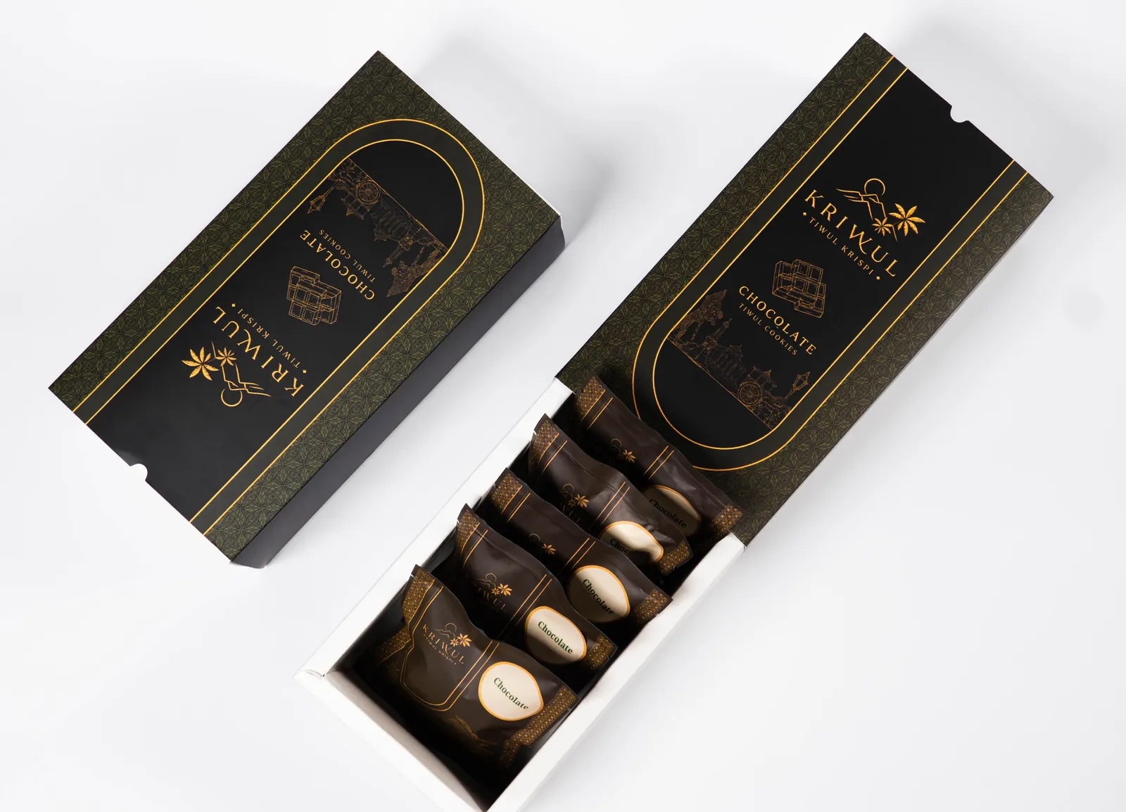 Kotak KriWul Chocolate terbuka dilihat dari atas: sleeve hitam bergaris emas di samping baki putih berisi lima pouch cokelat tua berlabel krem.